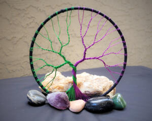 purple and green wire create this magical and mystical tree of life wrapped in black cotton yarn 
